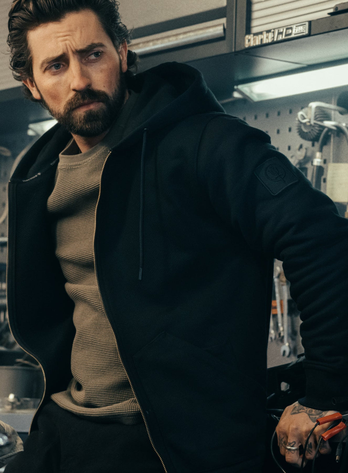 An in the field image of Men's Dissident Zipped Hoodie in Obsidian Black (ITF)