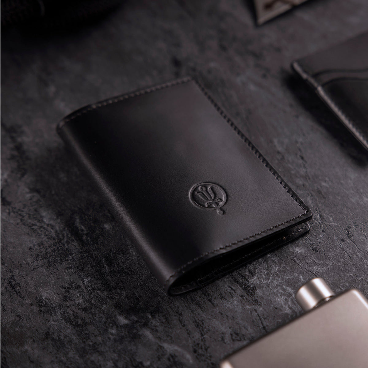 A creative studio shot of Leather Bi Fold Wallet in Black (CS)