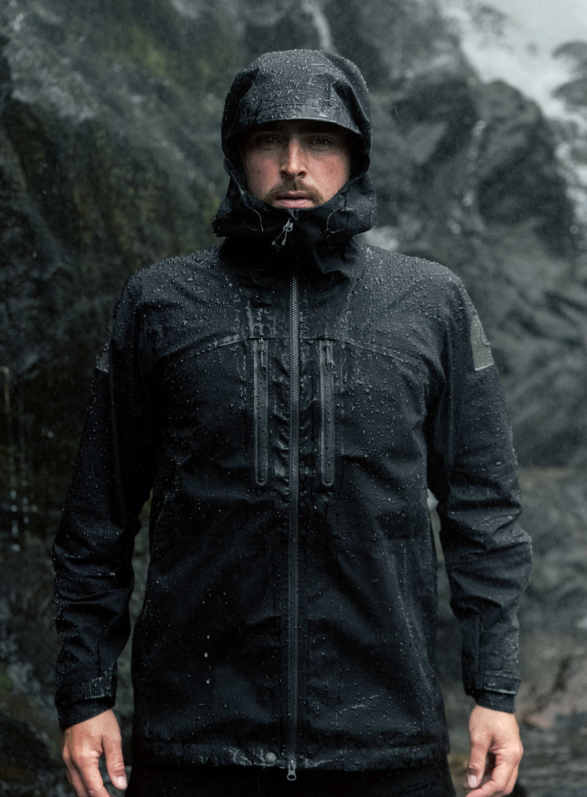 An in the field image of Men's Mountain Pro Waterproof Jacket in Obsidian Black (ITF)